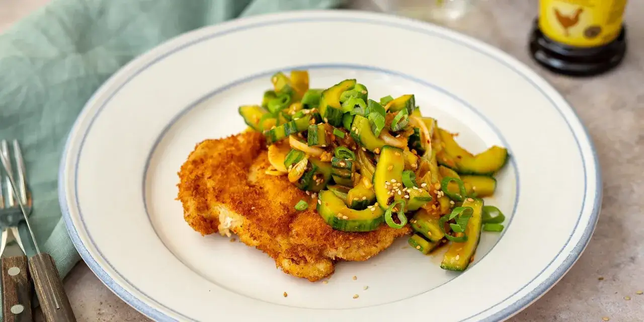 Krispig panerad schnitzel med en fräsch gurksallad toppad med sesamfrön och salladslök. En härlig kombination av texturer och smaker.