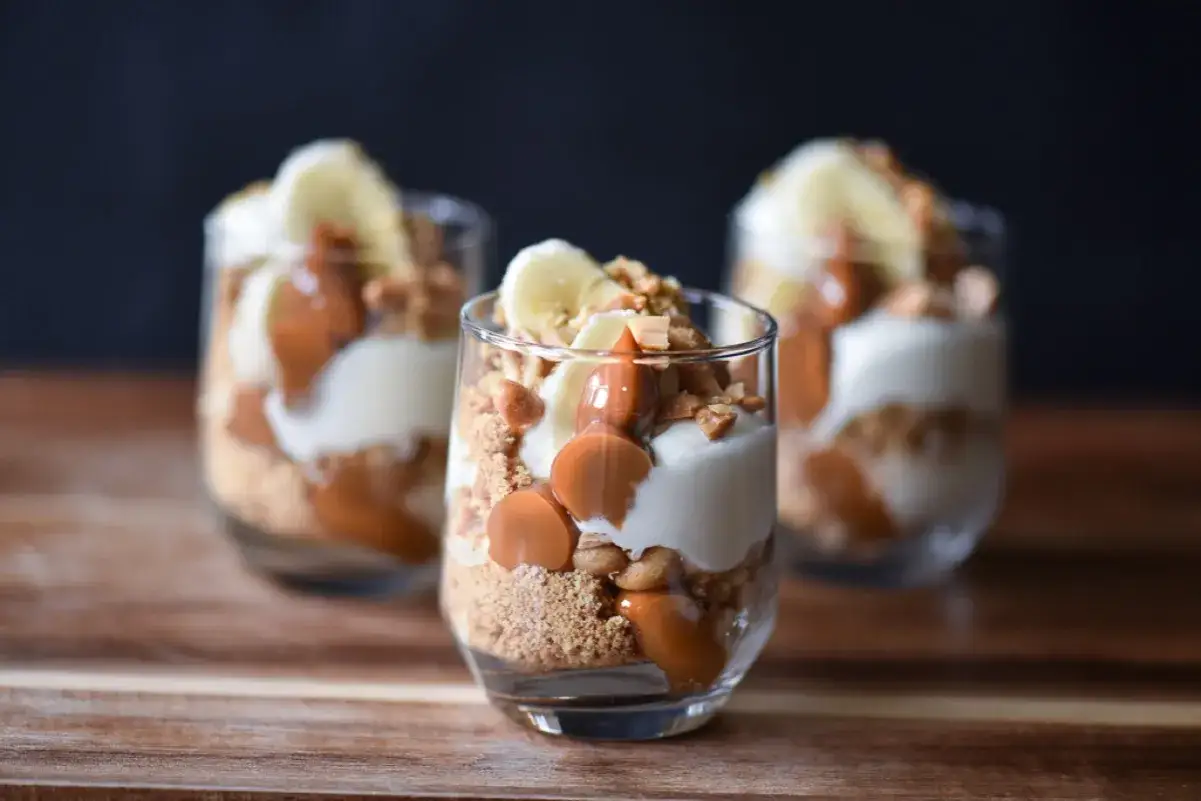 Tre l&auml;ckra banoffee paj i glas med banan, kolas&aring;s och kexsmulor.