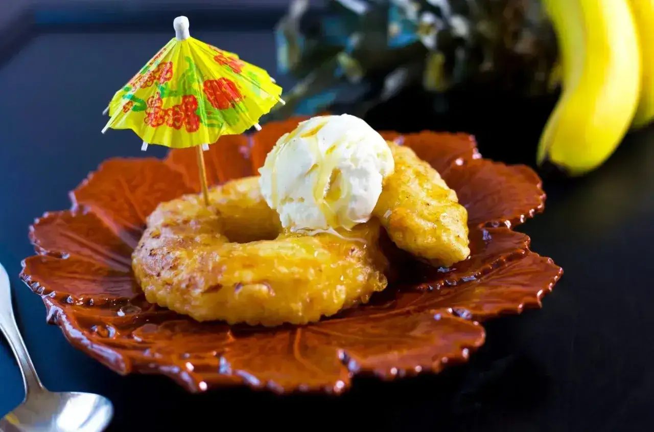 Friterad banan med vaniljglass och en liten gul parasoll. En l&auml;cker dessert som p&aring;minner om tropiska semester.