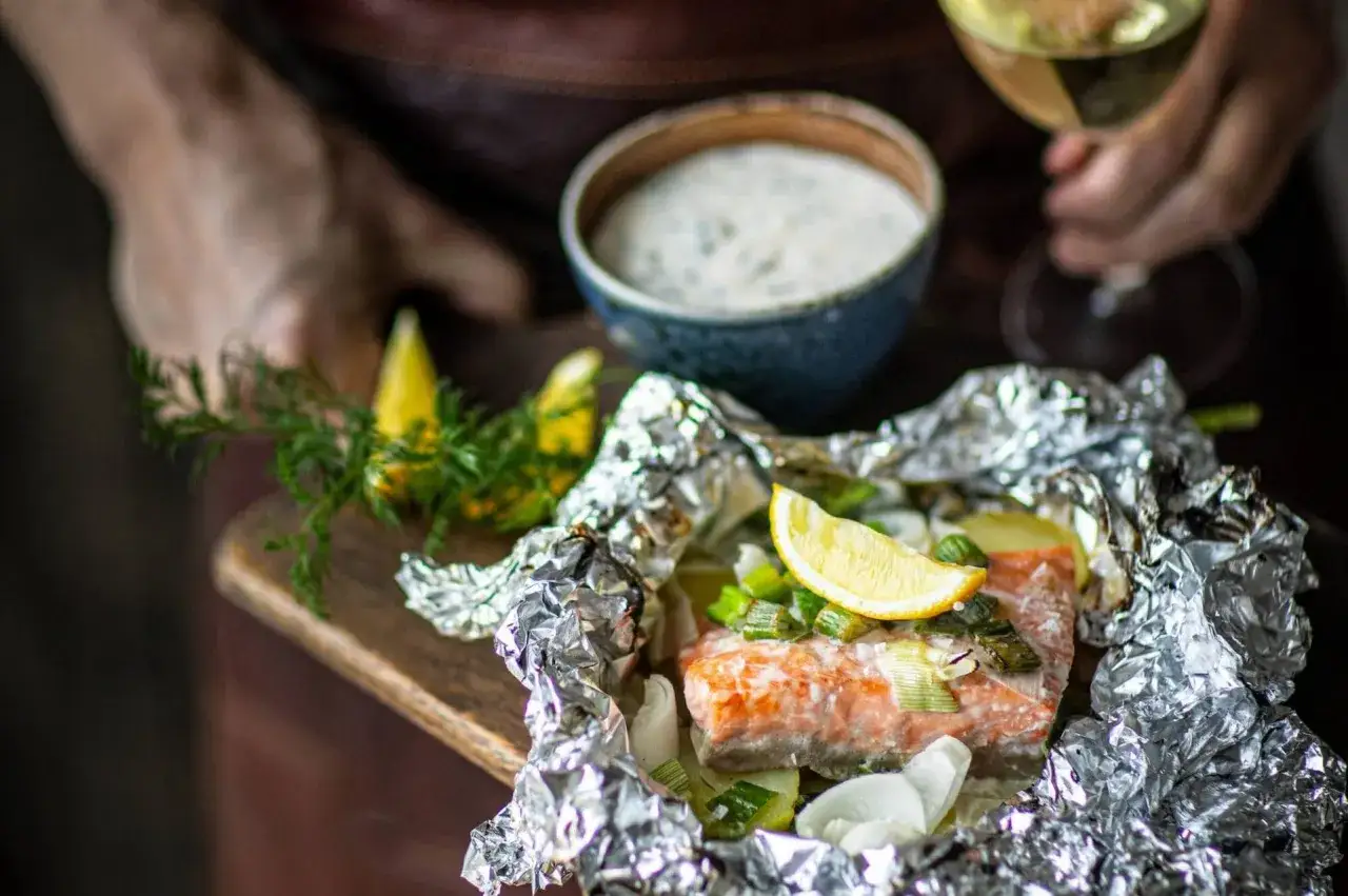 Ett saftigt laxpaket på grillen, serverat med citron och dill. En perfekt sommarmåltid.