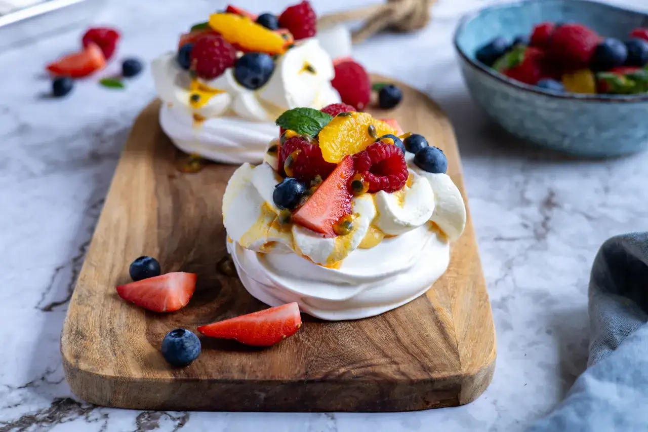 Två pavlovakupor med vispgrädde, färska bär, passionsfrukt och en härlig lemoncurd. En fest för ögat och gommen!
