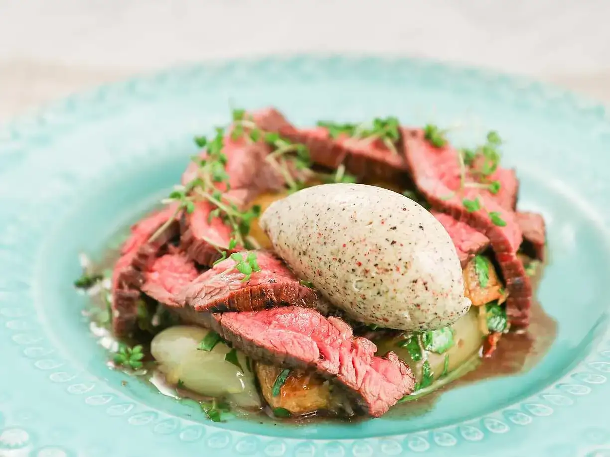 Skivad flankstek Morberg med potatis och en klick potatispur&eacute;, garnerad med &ouml;rter.